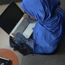 a person sitting on a couch with a laptop