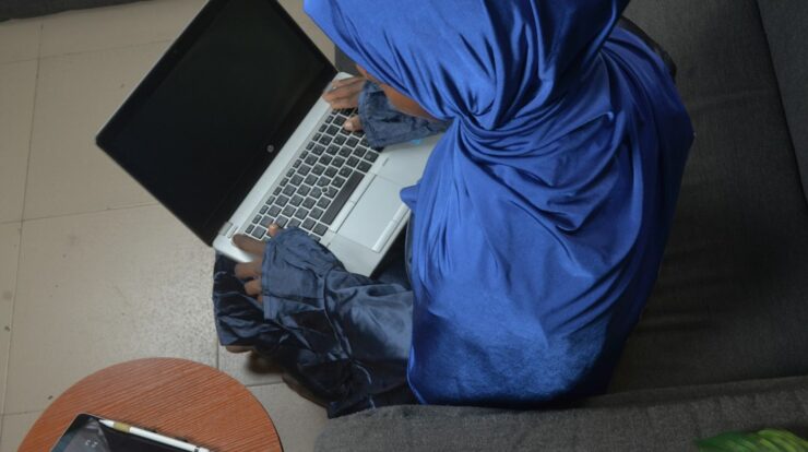 a person sitting on a couch with a laptop