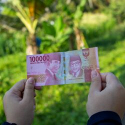 person holding 10000 indonesian rupiah