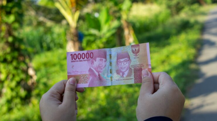 person holding 10000 indonesian rupiah