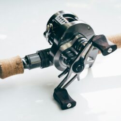 a fishing rod and reel on a white surface