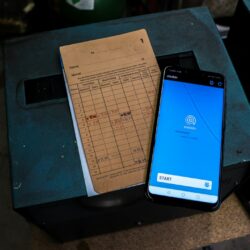 a cell phone sitting on top of a table next to a piece of paper