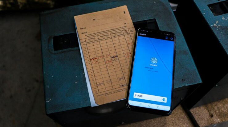 a cell phone sitting on top of a table next to a piece of paper