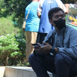 a man wearing a face mask sitting on a step
