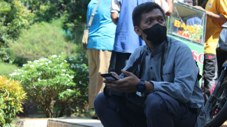 a man wearing a face mask sitting on a step