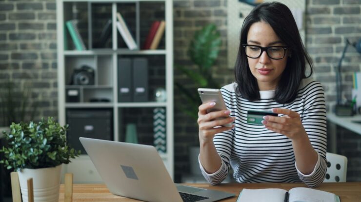 a woman sitting at a table looking at her cell phone