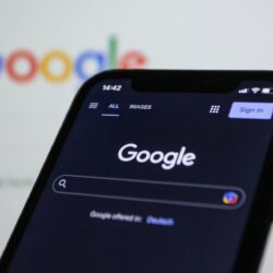 a close up of a cell phone with the google logo in the background