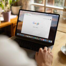 person using macbook pro on table