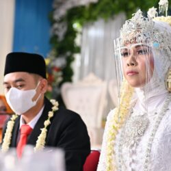 a man and a woman wearing masks sitting at a table