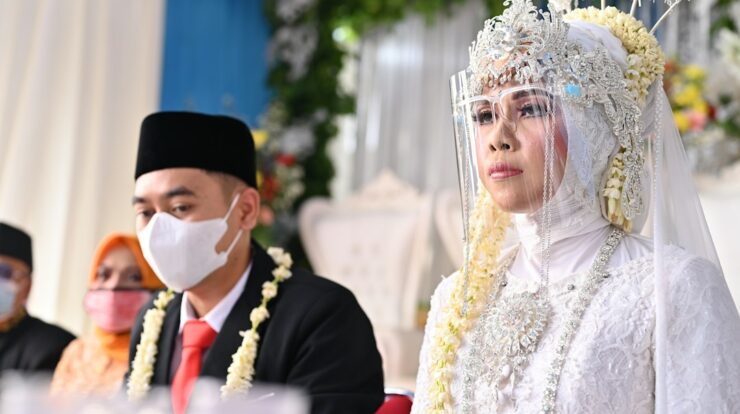a man and a woman wearing masks sitting at a table