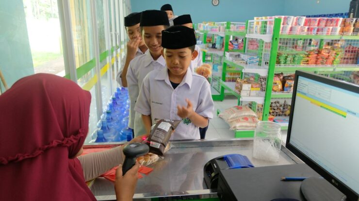 a woman is handing something to a boy in a store