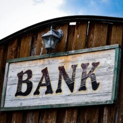 a bank sign on the side of a wooden building