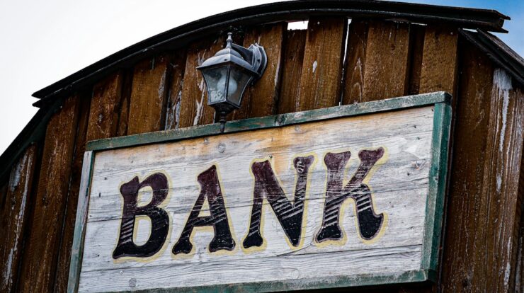 a bank sign on the side of a wooden building