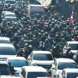 A large group of cars driving down a street