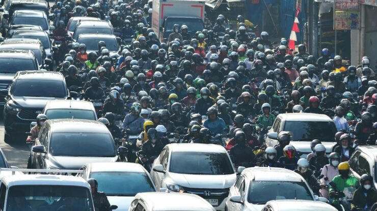A large group of cars driving down a street
