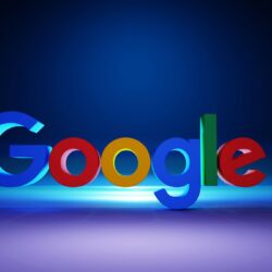 The Google logo in colorful 3D letters on a dark blue surface