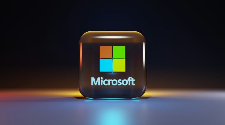 A glossy glass cube with the Microsoft logo on a dark surface