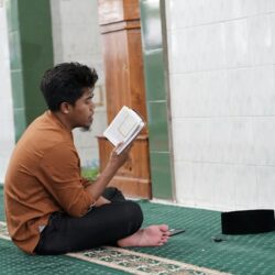 a person sitting on the floor reading a book
