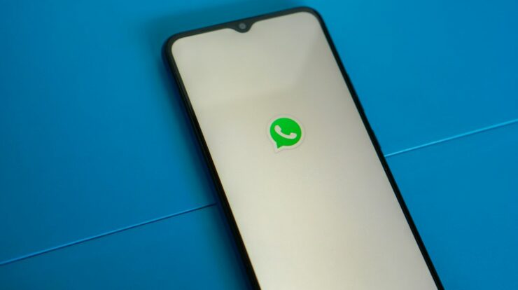 a white and black phone with a green whatsapp sticker on it