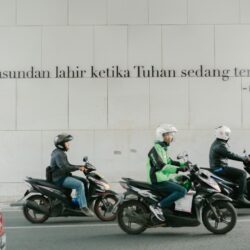 a group of people riding motorcycles down a street