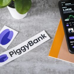 a cell phone sitting next to a piggy bank sticker