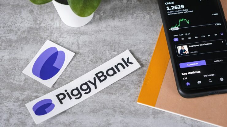 a cell phone sitting next to a piggy bank sticker
