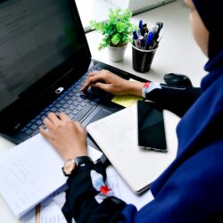 person in blue long sleeve shirt using black laptop computer