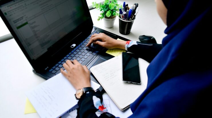 person in blue long sleeve shirt using black laptop computer