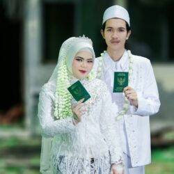Newlyweds holding marriage books in traditional attire