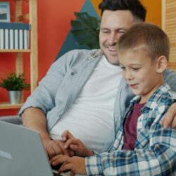 Father and son looking at laptop together