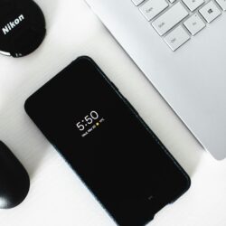 black Android smartphone beside grey laptop computer