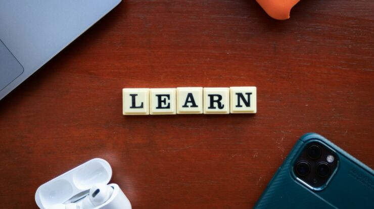 the word learn spelled with scrabble letters on a wooden table
