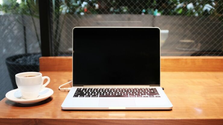 laptop computer beside coffee mug