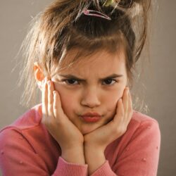a young girl with her hands on her face