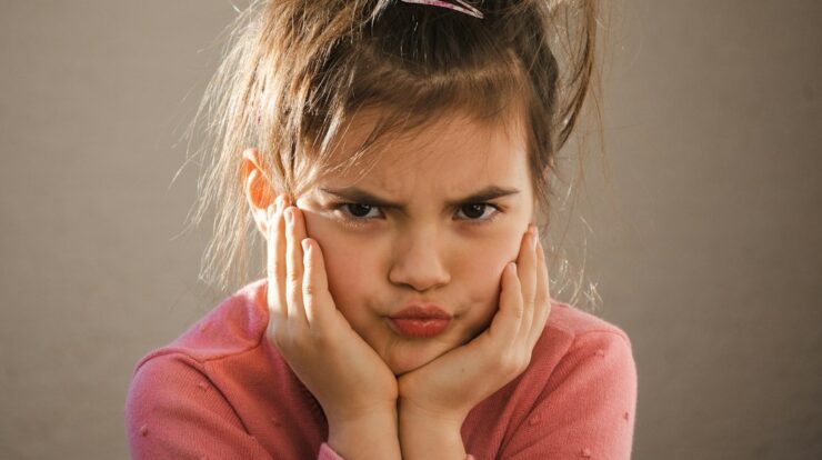 a young girl with her hands on her face