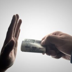 a person holding a stack of cash
