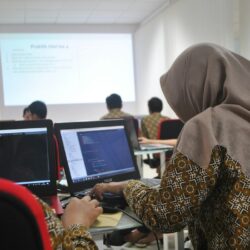 woman wearing grey hijab using laptop compiter