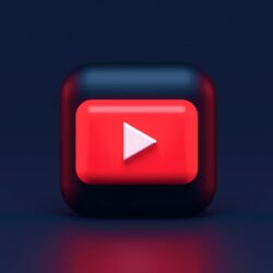 A 3D red play button icon on a dark blue background